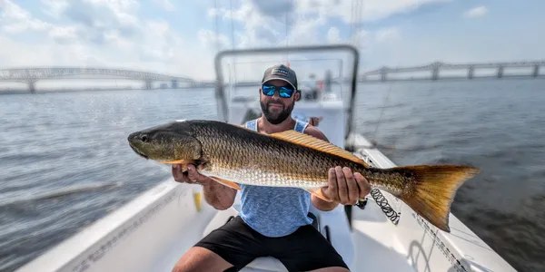 Tannic Water Adventures angler holding a large redfish aboard a bay boat