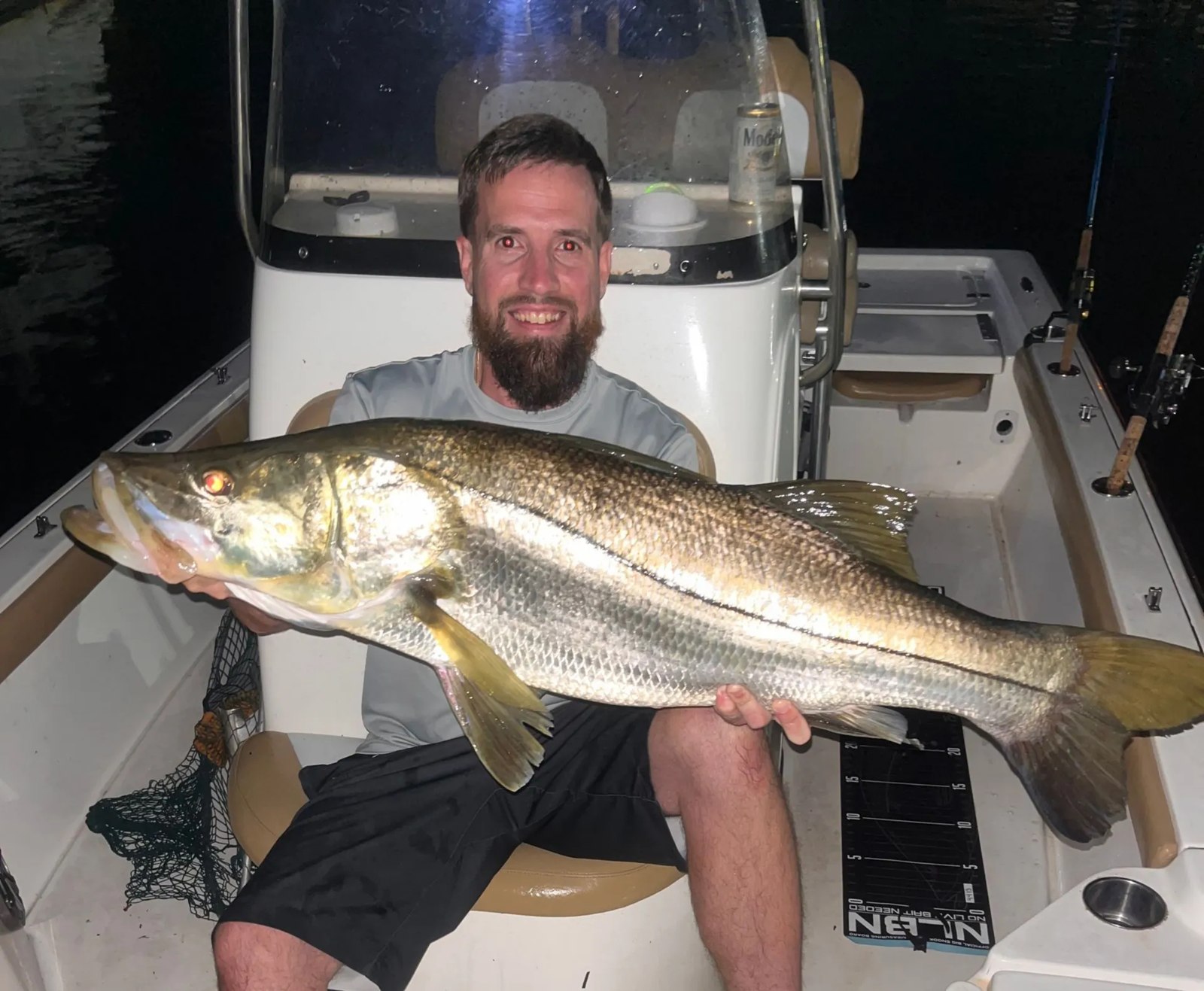 Tiki Fish angler holding a snook at night