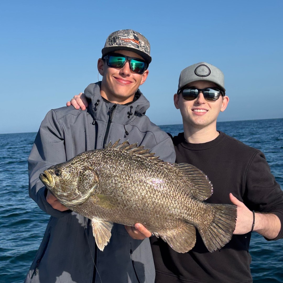 Salty Slam Charters anglers holding a tripletail