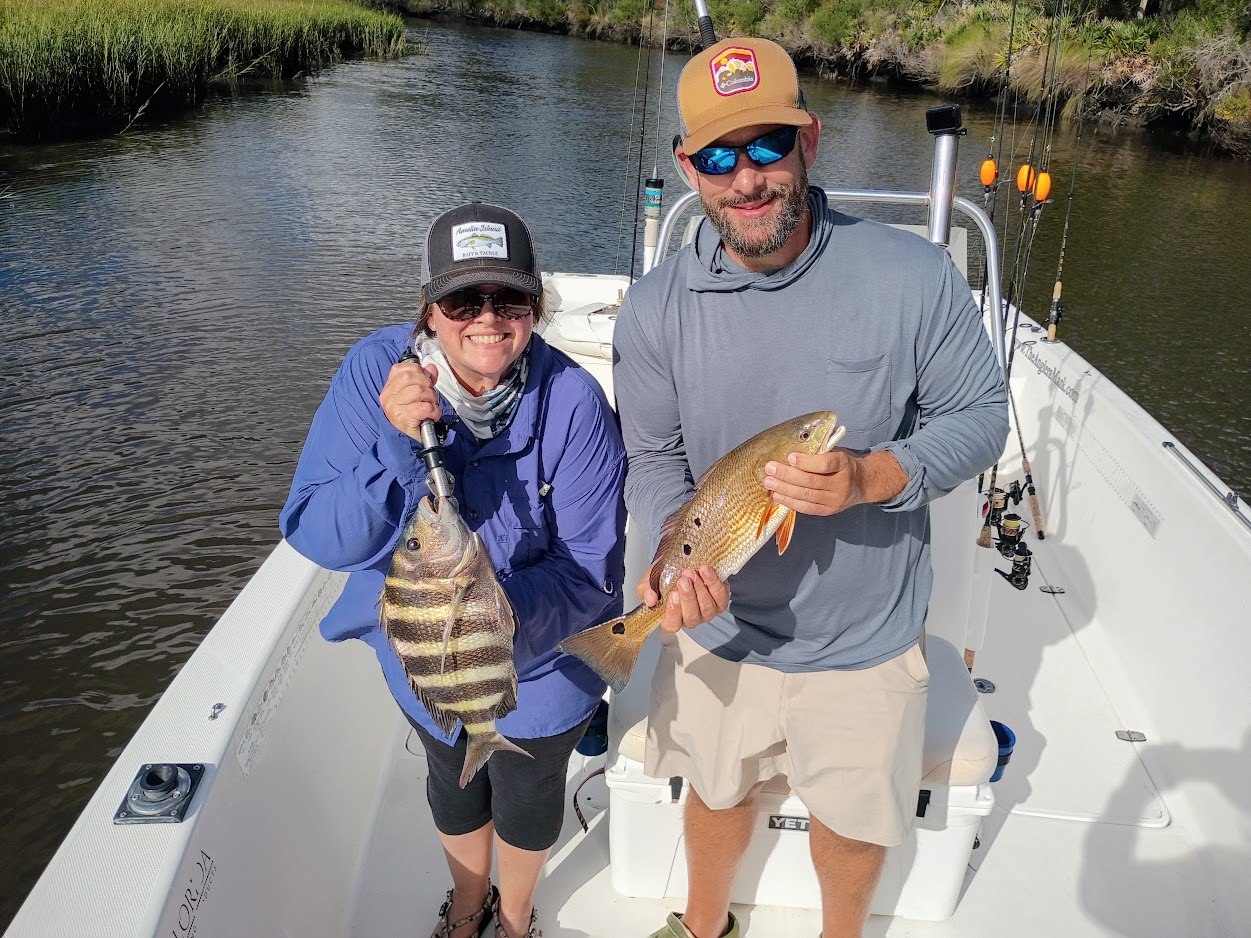 Two anglers with redfish aboard The Anglers Mark