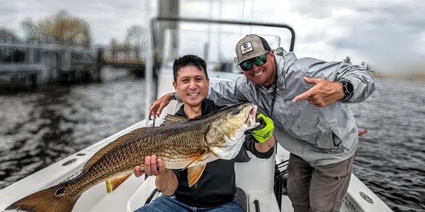 Two Tannic Water Adventures guests displaying a redfish on the St. Johns River
