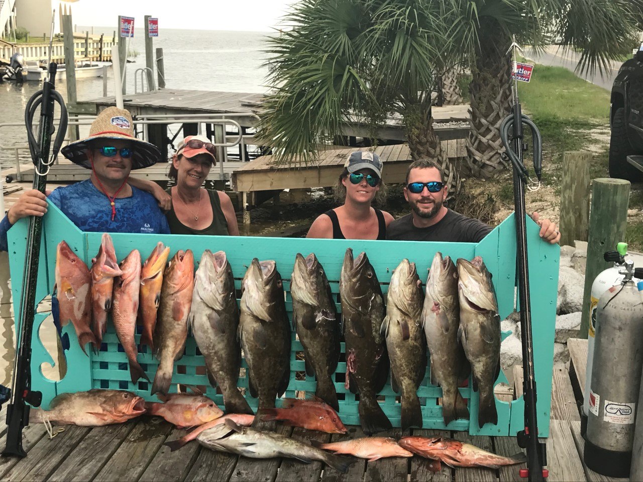 Up the Limit group beside a dockside fish display