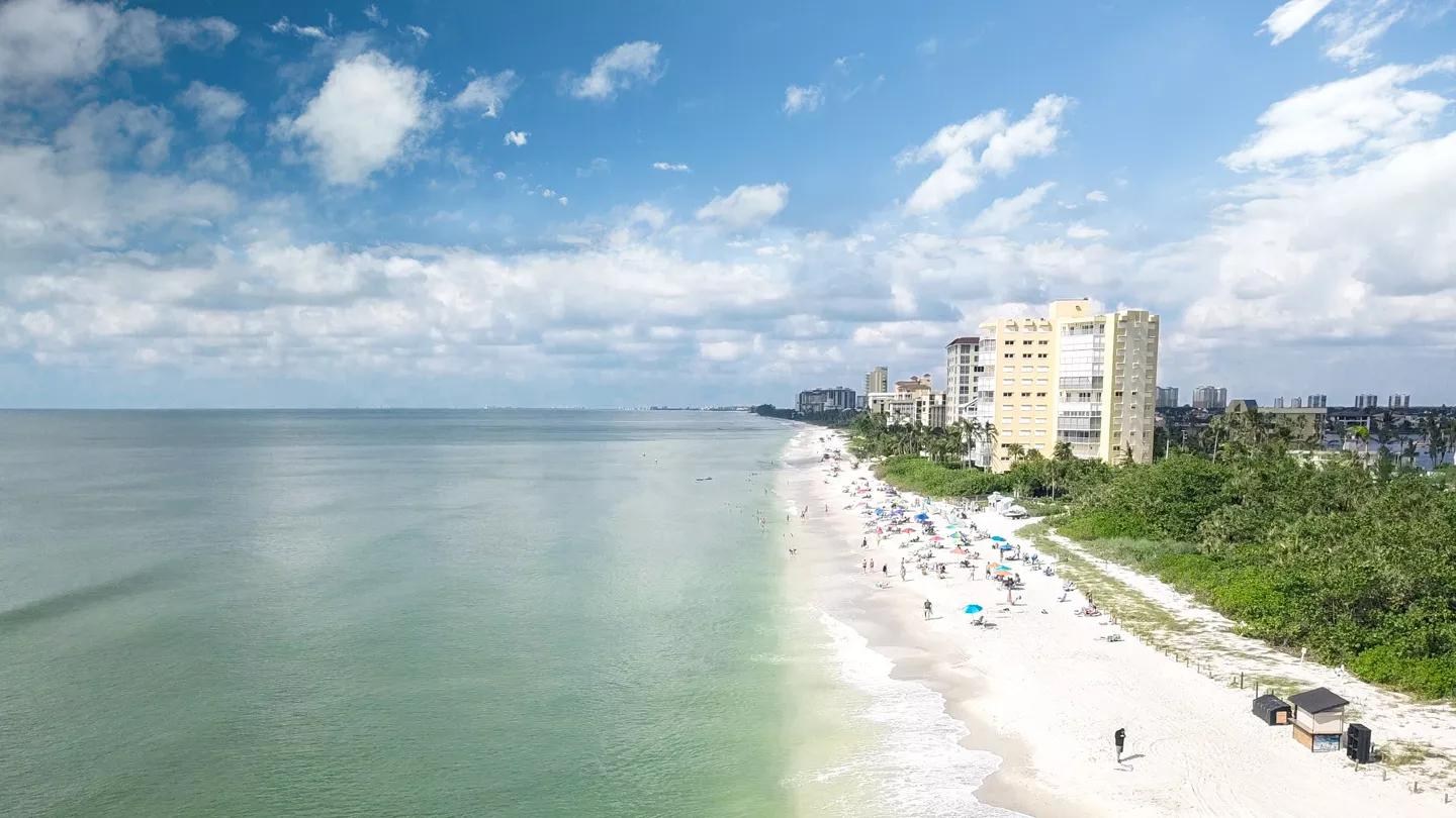 Vanderbilt Beach shoreline with buildings beyond the sand