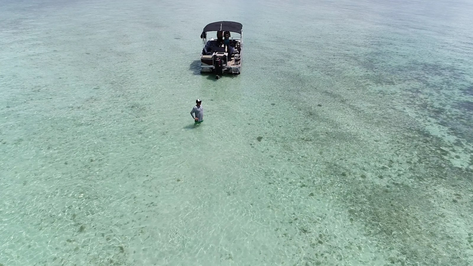 Walk The Plank boat anchored in shallow turquoise water