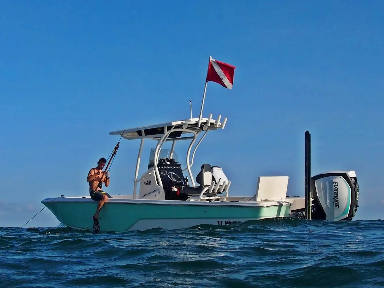 Wrecked Charters center-console boat in open water with a dive flag raised