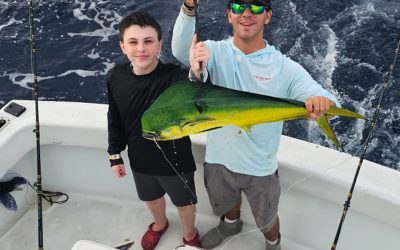Young angler displaying a mahi mahi aboard Don't Tell Mom Sportfishing