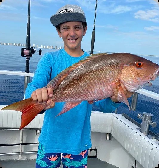 Young angler holding a snapper on a Seahorse fishing trip