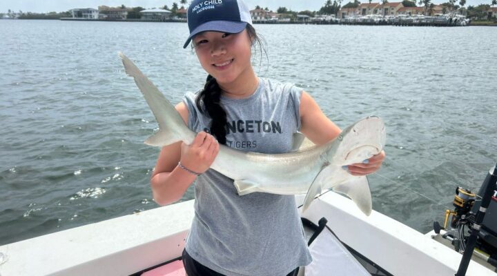 Young Mirisola angler holding a small shark