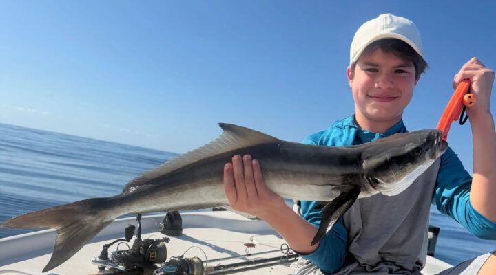Young Tiki Fish angler holding a cobia